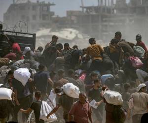 <i>Palestinos desplazados internamente intentan conseguir bolsas de harina de un camión de ayuda cerca de un punto de distribución de alimentos en Zikim, en el norte de la Franja de Gaza, el 8 de agosto de 2025. EFE/EPA/MOHAMMED SABER</i>