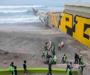 <i>Miembros de Border Angels y migrantes se manifiestan en la frontera entre Estados Unidos y México como parte del Día Internacional del Migrante en Playas de Tijuana, estado de Baja California, México, el 18 de diciembre de 2023. FOTO Guillermo Arias/AFP</i>