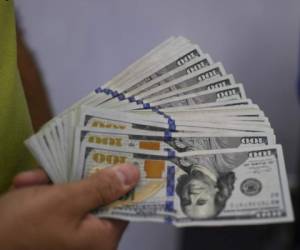 A shopper holds US dollar bills that he will use to buy in a store during Black Friday sales at a shopping centre in Caracas, Venezuela on November 29, 2019. - Stores at a shopping centre in Caracas joined Black Friday sales for its first time. (Photo by Yuri CORTEZ / AFP)