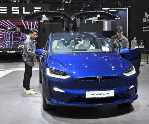 <i>Los visitantes miran un Tesla Model X durante una vista previa para la prensa del Salón de Movilidad de Seúl 2023 en la sala de exposiciones KINTEX en Goyang el 30 de marzo de 2023.Jung Yeon-je / AFP</i>