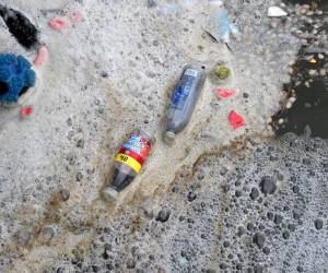 <i>Se muestra basura, incluidas botellas de plástico desechadas y envoltorios de alimentos, flotando en la superficie del agua en el lago Marine en West Kirby, en el noroeste de Inglaterra, el 22 de abril de 2024. FOTO Pablo ELLIS / AFP</i>