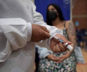 Una trabajadora de salud prepara la vacuna Pfizer-BioNTech para embarazada en Bogotá. (Photo by Raul ARBOLEDA / AFP)