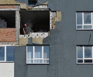 Un trabajador retira los escombros durante las obras de reparación de un bloque de apartamentos parcialmente destruido por los bombardeos en la ciudad de Irpin, región de Kyiv, el 16 de septiembre de 2022. Más de cien bloques residenciales en Irpin, apodada una “ciudad heroica” por el presidente Volodomyr Zelensky por retener ruso invasores que se dirigían a la capital- resultaron gravemente dañados por los bombardeos. Ahora, el avance del invierno presenta una amenaza diferente con reparaciones de edificios que se necesitan con urgencia para defenderse de los elementos.Serguéi SUPINSKY / AFP