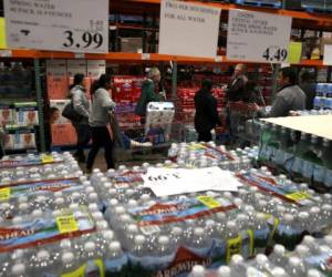 Los clientes hacen fila para recoger paquetes de papel higiénico en una tienda de Costco el 14 de marzo de 2020 en Novato, California. Algunos estadounidenses se están abasteciendo de alimentos, papel higiénico, agua y otros artículos después de que la Organización Mundial de la Salud (OMS) declaró que el coronavirus (COVID-19) era una pandemia. Justin Sullivan / Getty Images / AFP.