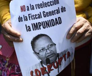 <i>ARCHIVO. Una persona sostiene un cartel contra la reelección de la fiscal general de Guatemala, Consuelo Porras, durante una protesta en la ciudad de Guatemala, el 6 de abril de 2022. FOTO Johan ORDÓNEZ / AFP</i>