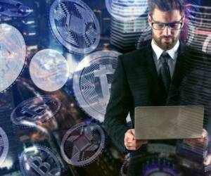 Handsome european businessman using laptop pn abstract night city background with bitcoins. Technology concept. Double exposure