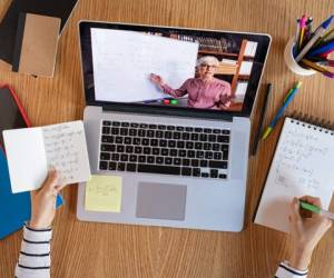 High angle view of video conference with teacher on laptop at home. College student learning maths while watching online webinar, listening audio course. Top view of girl in video call with personal tutor on computer, distance and e-learning education concept.