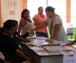<i>Personas votan durante la jornada de las elecciones generales este domingo, en San Pedro Sula (Honduras). EFE/ José Valle</i>