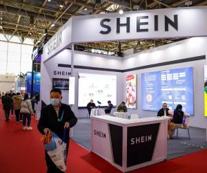 <i>Un hombre camina junto a un stand de Shein durante la Exposición Internacional de la Cadena de Suministro de China en Pekín. EFE/EPA/MARK R. CRISTINO</i>