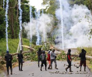 <i>Un manifestante se enfrenta con agentes de la Unidad de Control de Multitudes (UCM) este miércoles, en Valle de Agua Abajo en la provincia de Bocas del Toro (Panamá). Las fuerzas de seguridad de Panamá continúan con la 'Operación Omega' para tratar de despejar las vías en la provincia caribeña de Bocas del Toro, donde trabajadores del sector bananero se manifiestan desde hace más de un mes en contra de una reforma a la seguridad social. EFE/ Bienvenido Velasco</i>