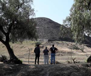 <i>Personas observan la zona arqueológica de Teotihuacán este martes, en San Juan Teotihuacán (México). Las puertas de la Zona Arqueológica de Teotihuacán (centro de México) permanecen cerradas y los alrededores de la Pirámide de la Luna, donde fueron baleadas varias personas en un tiroteo que dejó dos personas fallecidas, una de nacionalidad canadiense, y trece heridos, no está presente ningún elemento de seguridad, ni local ni federal. EFE/ Mario Guzmán</i>