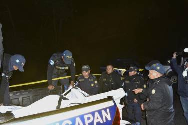 <i>Miembros de las fuerzas de seguridad guatemaltecas proceden a retirar los cuerpos de las víctimas después de que al menos quince personas murieran en la noche del viernes y otras diecinueve resultaran heridas durante un accidente de un bus de transporte público en el oeste de Guatemala, según confirmaron este sábado los cuerpos de socorro. EFE/ Fernando Estrada</i>