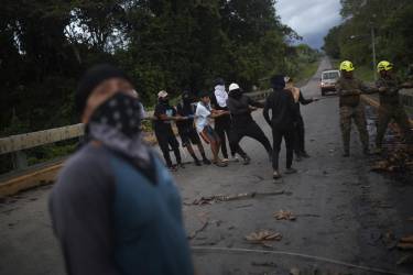 <i>Personas de la comunidad Piriati Embera ayudan a integrantes del Servicio Nacional de Fronteras a retirar unos cables eléctricos este jueves en Piriati (Panamá). EFE/ Bienvenido Velasco</i>