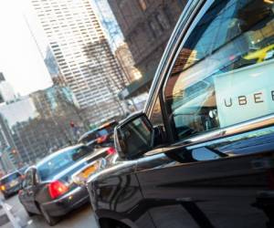 New York City, USA - March 5, 2016: Uber car service with sign in car window is waiting to pickup passengers on 6th Avenue in Manhattan, NY.