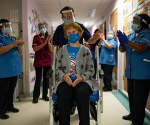 Margaret Keenan, 90, is applauded by staff as she returns to her ward after becoming the first person in the United Kingdom to receive the Pfizer/BioNtech COVID-19 vaccine at University Hospital, at the start of the largest ever immunisation programme in the British history, in Coventry, Britain December 8, 2020. Britain is the first country in the world to start vaccinating people with the Pfizer/BioNTech jab. Jacob King/Pool via REUTERS