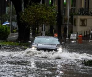 Un automóvil atraviesa la calle inundada durante fuertes lluvias y vientos mientras la tormenta tropical Eta se acerca al sur de Florida, en Miami, Florida, el 9 de noviembre de 2020. - La tormenta tropical Eta trajo fuertes vientos y lluvias torrenciales a Cuba el domingo después de haber cortado un Camino destructivo y mortal a través de partes de América Central y el sur de México. (Foto de CHANDAN KHANNA / AFP)