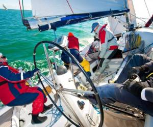 Captain steers yacht in race --- Image by © Ocean/Corbis