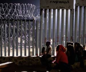 Migrants from Guatemala, part of the Central American migrant caravan, are seen near the US-Mexico border fence in Playas de Tijuana, Baja California state, Mexico on December 9, 2018. - Thousands of Central American migrants, mostly Hondurans, have trekked for over a month in the hopes of reaching the United States. (Photo by Guillermo Arias / AFP)