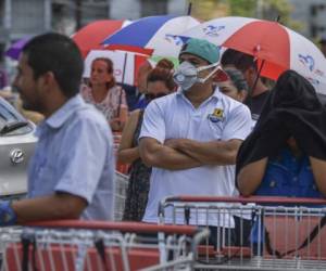 People wait for their turn to enter a supermarket in Panama City, on March 16, 2020, following the announcement by the Panamanian government to restrict access to 50 people per supermarket as a precautionary measure against the new coronavirus, COVID-19, pandemic. - Quarantine, schools, shops and borders closed, gatherings banned, are the main measures being taken in many countries across the world to fight the spread of the novel coronavirus. (Photo by Luis ACOSTA / AFP)