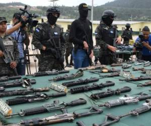 Police and military specialized units personnel custody an assortment of assault rifles and ammo seized to members of the Barrio 18 and Mara Salvatrucha gangs after an operation laubched at the Marco Aurelio Soto national penitentiary in Tamara, 20 km north of Tegucigalpa, on August 29, 2017. / AFP PHOTO / ORLANDO SIERRA