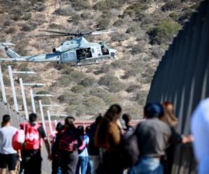 A United States Military helicopter flies past a pedestrian bridge after the closing of the United States-Mexico border was ordered on November 25, 2018 at the San Ysidro border crossing point south of San Diego, California. - US officials closed a border crossing in southern California on Sunday after hundreds of migrants tried to breach a border fence from the Mexican city of Tijuana, US authorities announced. The US Customs and Border Protection office in San Diego, California, said on Twitter that it had closed both north and south access to vehicle traffic at the San Ysidro border post, before also suspending pedestrian crossings. (Photo by Sandy Huffaker / AFP)