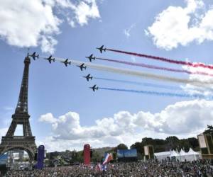 La patrulla aérea francesa 'Patrouille de France' sobrevuela la aldea de fans de El Trocadero frente a la Torre Eiffel, en París, el 8 de agosto de 2021 tras la transmisión de la ceremonia de clausura de los Juegos Olímpicos de Tokio 2020. (Foto de STEPHANE DE SAKUTIN / AFP)