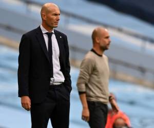 Real Madrid's French coach Zinedine Zidane (L) and Manchester City's Spanish manager Pep Guardiola watch the players from the touchline during the UEFA Champions League round of 16 second leg football match between Manchester City and Real Madrid at the Etihad Stadium in Manchester, north west England on August 7, 2020. (Photo by Shaun Botterill / POOL / AFP)