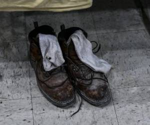 Un par de zapatos pertenecientes a un migrante se sientan en un refugio en San Antonio, Texas, el 29 de junio de 2022. - Decenas de inmigrantes esperan en fila afuera de un refugio en San Antonio, la mayoría hombres jóvenes pero también algunas mujeres y niños, esperando para una comida caliente y un techo sobre su cabeza. (Foto de CHANDAN KHANNA / AFP)