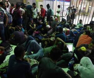 People wait to board a bus leaving the Metropolitan Center of San Pedro Sula, 300 kms north of Tegucigalpa, to travel to the Guatemala border on January 14, 2020, in an attemp to reach get to the US. (Photo by ORLANDO SIERRA / AFP)