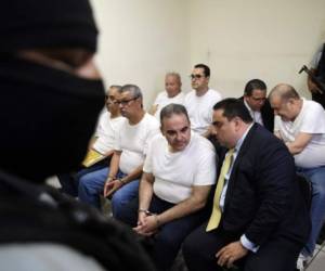 Former Salvadoran President (2004-2009) Elias Antonio Saca (C) talks with his lawyer as he waits to hear his sentence alonside five of his collaborators at a courtroom in San Salvador on September 12, 2018.Saca was sentenced to ten years in jain for the diversion of 301 million dollars during his term of office. / AFP PHOTO / MARVIN RECINOS