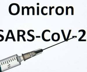 An illustration picture taken on December 17, 2021 shows a syringe in front of words 'Omicron SARS-CoV-2'. (Photo by Kirill KUDRYAVTSEV / AFP)
