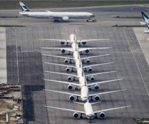 A Cathay Pacific passenger airplane (top) is taxied onto the runway as other aircrafts belonging to the local flagship carrier are seen parked on the tarmac at Hong Kong's Chek Lap Kok International Airport on March 10, 2020. - Hong Kong's flagship carrier Cathay Pacific is expected to release its full-year financial results on March 11. (Photo by Anthony WALLACE / AFP)