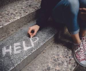 Teenage girl sitting on a staircase outside feeling depressed