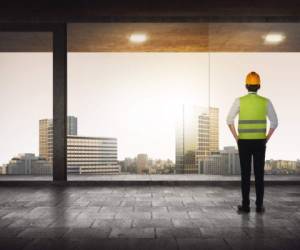 Back view of successful manager looking the city from his office