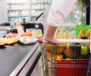 Person buying food products in the supermarket queue