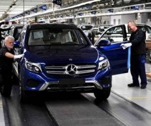 Employees work on an assembly line for Mercedes-Benz GLC sports utility vehicle (SUV) at the luxury automaker's factory in Bremen, Germany, on January 24, 2017. / AFP PHOTO / PATRIK STOLLARZ