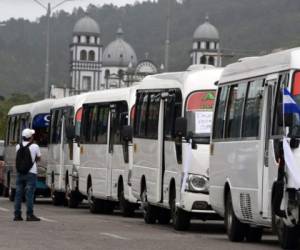 Transport workers protest in demand of a reduction in the price of fuel, in Tegucigalpa, on July 20 2018. Public service transport workers who blocked roads across Honduras last week, demanding the government of President Juan Orlando Hernandez a reduction in the price of fuel, resumed activities on Friday to continue negotiating, but since talks failed they threat to go on strike again on Monday. / AFP PHOTO / ORLANDO SIERRA