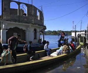 Residentes viajan en bote por una calle inundada de la comunidad indígena Comunidad Campur, Guatemala, el 10 de diciembre de 2020. - La comunidad indígena de Campur en el norte de Guatemala se ha convertido en una laguna luego del paso de los huracanes Eta e Iota, que dejaron 160 muertos y desaparecido en el país. (Foto de Johan ORDONEZ / AFP)