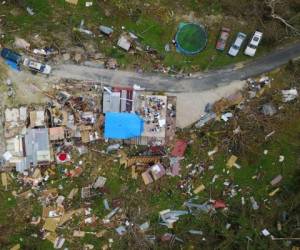 A house destroyed by hurricane winds is seen in Corozal, west of San Juan, Puerto Rico, on September 24, 2017 following the passage of Hurricane Maria.Authorities in Puerto Rico rushed on September 23, 2017 to evacuate people living downriver from a dam said to be in danger of collapsing because of flooding from Hurricane Maria. / AFP PHOTO / Ricardo ARDUENGO