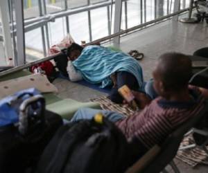 A passenger rests on the floor of Terminal 5 of London's Heathrow Airport on May 29, 2017.Passengers faced a third day of disruption at Heathrow Monday as British Airways cancelled short-haul flights after a global computer crash that unions blamed on the outsourcing of IT services to India. The embattled airline said it was cancelling 13 short-haul flights from Heathrow Airport, Europe's busiest, but was aiming to operate a full long-haul schedule from the hub and was operating a full service from Gatwick Airport. / AFP PHOTO / Daniel LEAL-OLIVAS