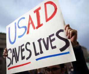 <i>Un manifestante sostiene un cartel frente a la Agencia de los Estados Unidos para el Desarrollo Internacional (USAID) en Washington, DC, EE.UU., en una fotografía del 03 de febrero de 2025. EFE/WILL OLIVER</i>