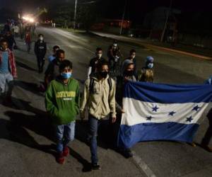 Unos 300 hondureños parten en caravana rumbo a Estados Unidos, huyendo de la violencia y crisis provocada por los huracanes Eta e Iota, desde la Gran Central Metropolitana de San Pedro Sula, 180 km al norte de Tegucigalpa, el 14 de enero de 2021 (Foto de Orlando). SIERRA / AFP)