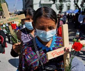 An indigenous Mayan woman takes part in a protest to commemorate the 25th anniversary of the signing of the Guatemalan Peace Agreement, which put an end to the Guatemalan Civil War (1960-1996), at Constitution Square, in Guatemala City, on December 29, 2021. - Guatemala commemorated this Wednesday the 25th anniversary of the end of the civil war, which in more than 36 years left tens of thousands dead and missing, without bringing peace and development to the Central American country, local indigenous victims of the violence denounced. (Photo by Johan ORDONEZ / AFP)