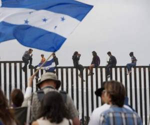 A resident of La Blanca gives beverages to Honduran migrants taking part in a caravan heading to the US as they ride on a truck on their way from Santiago Niltepec to Juchitan, near the town of La Blanca in Oaxaca State, Mexico, on October 30, 2018. - The Pentagon is deploying 5,200 active-duty troops to beef up security along the US-Mexico border, officials announced Monday, in a bid to prevent a caravan of Central American migrants from illegally crossing the frontier. (Photo by GUILLERMO ARIAS / AFP)