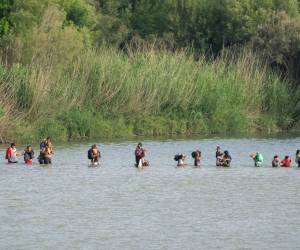 <i>Los migrantes cruzan el Río Grande desde el lado mexicano de la frontera hacia los EE. UU. el 16 de julio de 2023 vistos desde Eagle Pass, Texas. (Photo by SUZANNE CORDEIRO / AFP)</i>