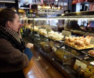 El éxito de la tapa no se entiende, no obstante, sin su particular forma de comerla: preferentemente con las manos, de pie, compartiendo, y pasando de bar en bar para probar cuanto más mejor. (Foto: AFP).