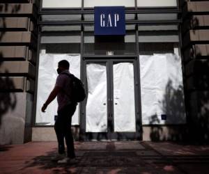 SAN FRANCISCO, CALIFORNIA - AUGUST 18: A pedestrian walks by the closed GAP flagship store on August 18, 2020 in San Francisco, California. Gap Inc. announced that they will permanently close its flagship store in San Francisco and all but one store in the city due to a drop in retail sales as the coronavirus COVID-19 pandemic continues. Justin Sullivan/Getty Images/AFP