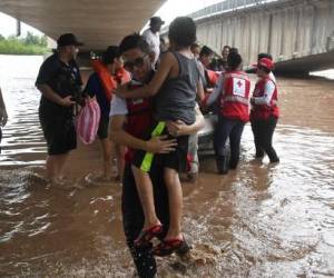 Efectivos de la cruz roja hondureña rescatan a habitantes de El Progreso, Honduras, tras el desbordamiento del río Ulúa el 24 de septiembre de 2022. - Honduras declaró alerta roja en la región noroeste del país por el azote de lluvias torrenciales que provocó la desborde de ríos, dejando al menos 13 muertos durante la última semana y más de 200 viviendas destruidas por derrumbes en la capital hondureña. (Foto por Orlando SIERRA / AFP)