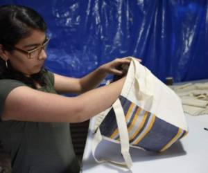 Alejandra Marroquin checks a cotton bag inspired in Mayan costumes -made within an attempt to put a curb on the abuse of plastic usage- in Perez Guizasola neighborhood in Guatemala City, on February 22, 2018. / AFP PHOTO / JOHAN ORDONEZ / TO GO WITH AFP STORY by HENRY MORALES ARANA