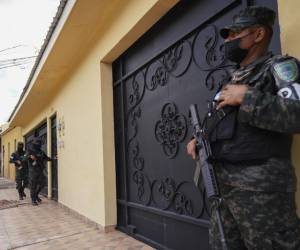 Miembros de la Policía Militar de Honduras hacen guardia en una lujosa casa durante un allanamiento en Tegucigalpa el 12 de diciembre de 2022. - Diez casas de lujo fueron allanadas en Honduras el lunes por fiscales y policías en busca de pruebas para combatir los cárteles de la droga, dijo el Ministerio Público. . (Foto por Johny Magallanes / AFP)